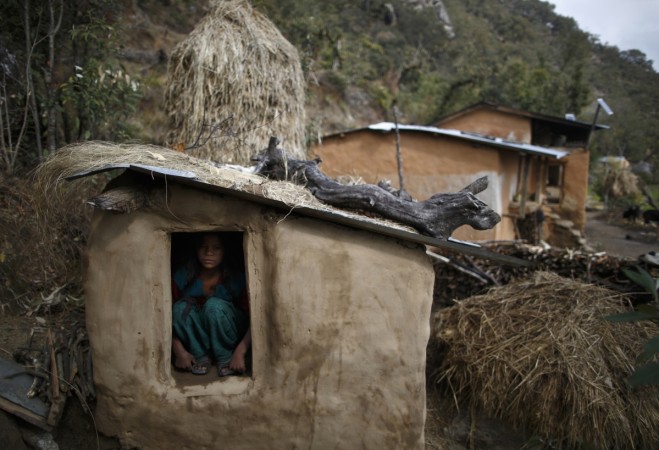 A teenage girl sits inside a Chaupadi shed in the hills of Legudsen village in Achham District in western Nepal during menstruation. Menstrual huts