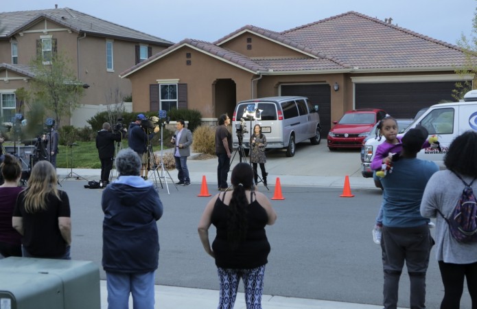 Perris, California, residents watch as media gather in front of 160 Muir Woods Road from where authorities rescued 13 malnourished children held captive by their parents Turpin residence
