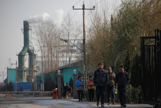 Smoke billows from a chimney as workers leave a factory in rural Gaoyi county, known for its ceramics production, near Shijiazhuang, Hebei province, China, December 7, 2017. Picture taken December 7, 2017. China air pollution