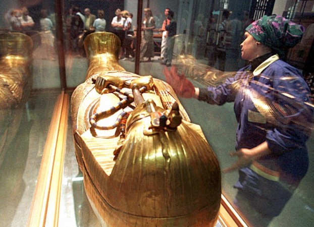 An Egyptian worker cleans the glass case around the sarcophagus of Tutankhamun in the Egyptian Museum 30 November. Tutankhamun