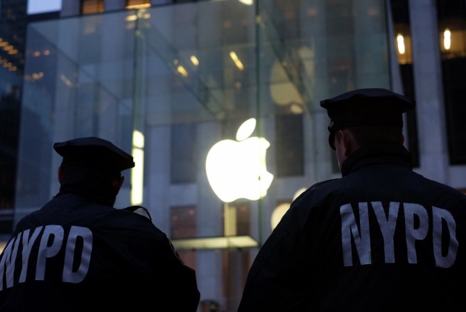 Two New York Police Department (NYPD) officers stand guard near the Apple store on Fifth Avenue in New York during an anti-government demonstration on February 23, 2016. Apple introduces new iOS 12 that will help save lives