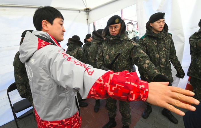 South Korean soldiers inspect a visitor at a security checkpoint as they replace security guards showing symptoms of the norovirus at the Gangneung Ice Arena in Gangneung on February 6, 2018 ahead of the Pyeongchang 2018 Winter Olympic Games. Norovirus at Winter Olympics 2018