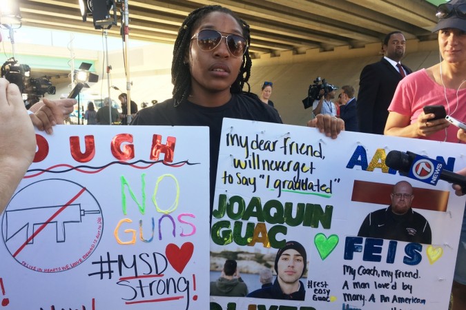 In picture: Tyra Hemans, a 19-year-old senior at Marjory Stoneman Douglas High School, sobs as she holds signs honoring slain teachers and friends near the police cordon around the school in Parkland Florida, U.S., February 15, 2018. Florida school shooting