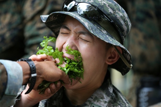 A South Korea marine eats local vegetables during a jungle survival exercise as part of the Us marines