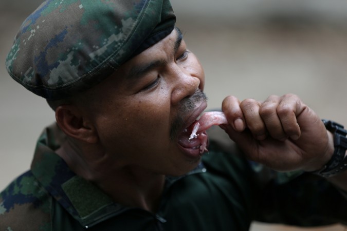 Thai Navy instructor eats a geko during a jungle survival exercise as part of the Us marines