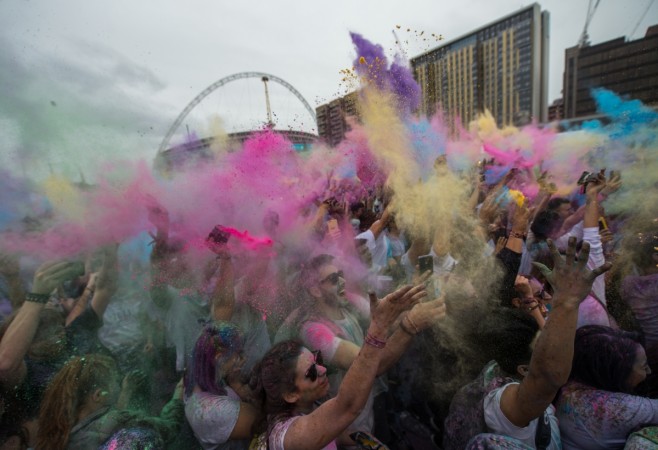People dance and throw brightly coloured powder at the Holi Festival of Colours at Wembley Park on July 29, 2017 in London, England. The event is inspired by the spring festival, Holi, which is celebrated by Hindus primarily in India, Nepal, Bangladesh and Pakistan. Holi 2018