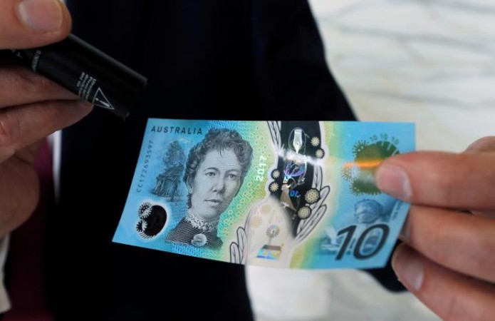 Australia's Reserve Bank Assistant Governor of Business Services Lindsay Boulton uses an ultraviolet light to display security features of the new A$10 bank note on the first day of its introduction into the Australian economy in Sydney, Australia, September 20, 2017. Australia banknote