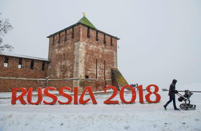 A man pushes a stroller past a FIFA World Cup 2018 emblem placed in front of the Nizhny Novgorod's Kremlin A man pushes a stroler past a FIFA World Cup 2018 emblem placed in front of the Nizhny Novgorod's Kremlin