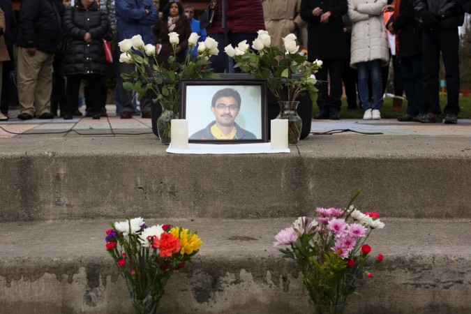 A picture of Srinivas Kuchibhotla surrounded by roses during a vigil in honor of him. srinivas kuchibhotla
