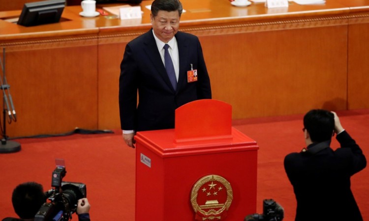 Chinese President Xi Jinping looks on after dropping his ballot during a vote on a constitutional amendment lifting presidential term limits, at the third plenary session of the National People's Congress (NPC) at the Great Hall of the People in Beijing, China, on March 11, 2018. Xi jinping