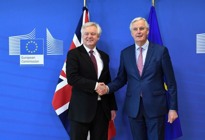 British Brexit minister David Davis (L) and EU chief negotiator Michel Barnier shake hands as they meet at the European Commission in Brussels on March 19, 2018. UK, EU reach Brexit transition deal