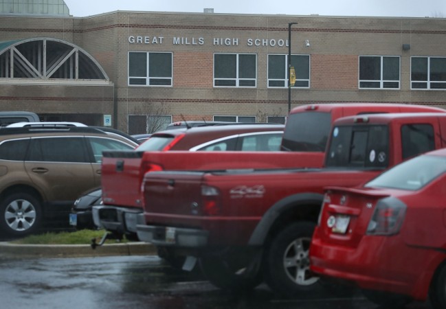 Student's vehicles sit in front of Great Mills High School after a shooting on March 20, 2018, in Great Mills, Maryland. It was reported that two students at a Maryland high school were injured after a colleague opened fire in the hallway just before classes began. Maryland school shooting