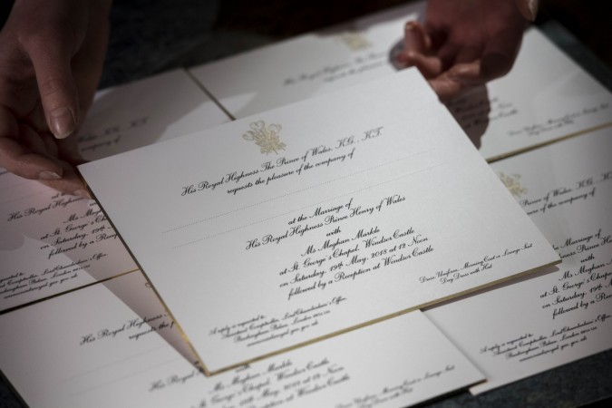 Hands hold invitations just printed at the workshop of Barnard and Westwood for Prince Harry and Meghan Markle's wedding on March 22, 2018 in London, England. The couple will marry in St. George's Chapel at Windsor Castle on May 19. Prince Harry Meghan Markle wedding invite