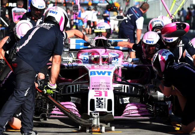 Mechanics change the tyres of Force India's French driver Esteban Ocon during the second Formula One practice session in Melbourne on March 23, 2018 Force India F1
