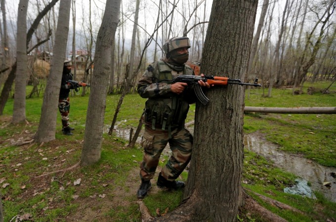 Indian Army soldiers take their positions near the site of a gunbattle on the outskirts