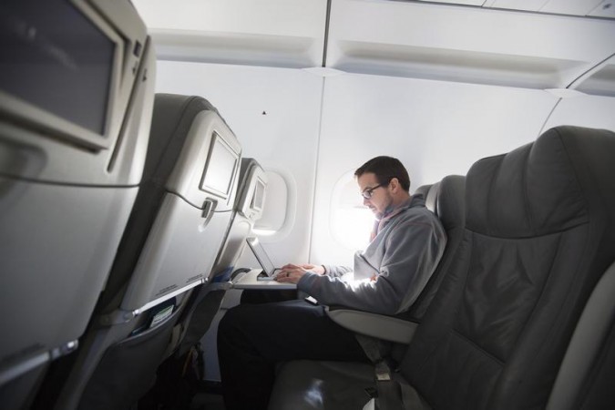 A man uses his laptop while on a special JetBlue media flight out of John F. Kennedy International Airport in New York. onboard wifi