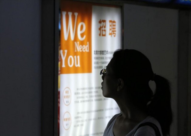 A job seeker looks at a job advertisement board at a Beijing talent service centre. china job ads