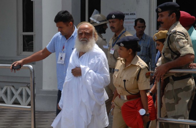 Indian spiritual guru Asaram Bapu (C) is escorted by police, after he was arrested from his Indore ashram, at the airport in Jodhpur on September 1, 2013. self-styled godman Asaram Bapu