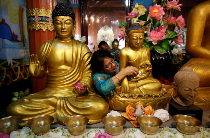 A devotee places flowers in front of a statue of Lord Buddha at a temple on the occasion of the Buddha Purnima festival, also known as Vesak Day, in Kolkata, India, April 29, 2018. Lord Buddha