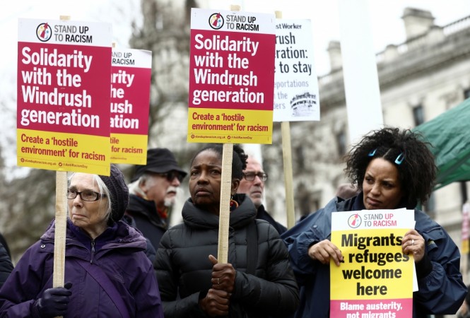 People hold placards during a demonstration to protest against the treatment of members of the Windrush generation Windrush generation