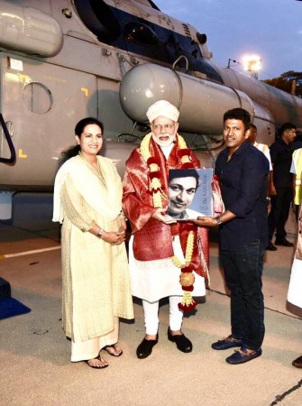 Narendra Modi receives Dr Rajkumar's biography, The Person Behind the Personality, from Puneeth Rajkumar. The actor's wife Ashwini is also seen in the picture. Narendra Modi receiving Dr Rajkumar's biography from Puneeth Rajkumar