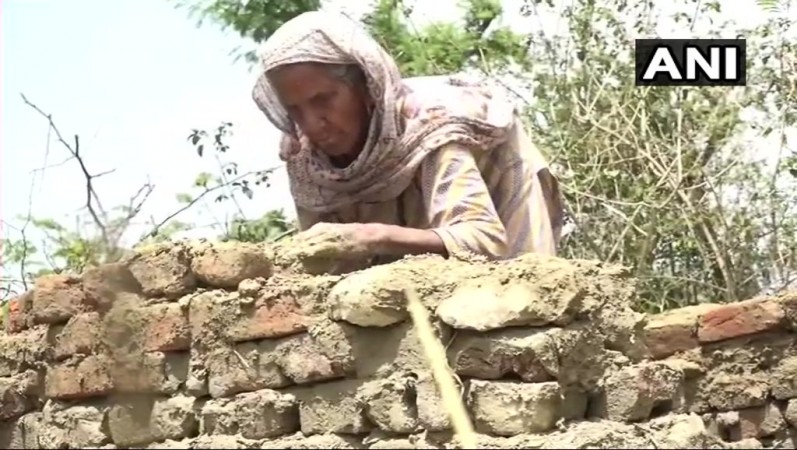The elderly woman constructed the toilet with her own hands. building toilet