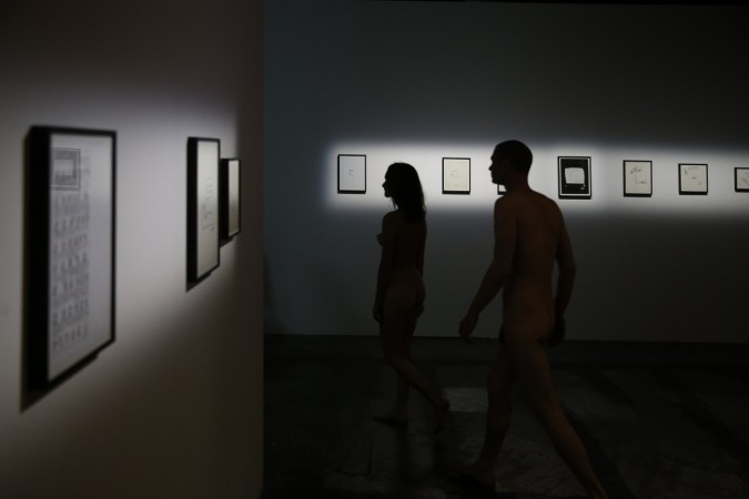 People take part in a nudist visit of the 'Discorde, Fille de la Nuit' season exhibition at the Palais de Tokyo museum in Paris on May 5, 2018 Paris museum opens doors for naked visitors