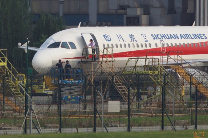 The Sichuan Airlines flight being inspected after the windshield broke off. sichuan airlines