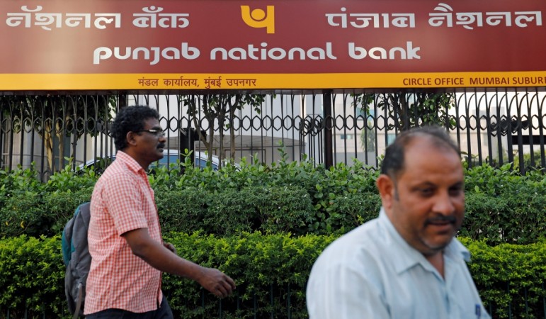 File photo- Pedestrians walk past a Punjab National Bank office in Mumbai, India February 21, 2018. Punjab National Bank