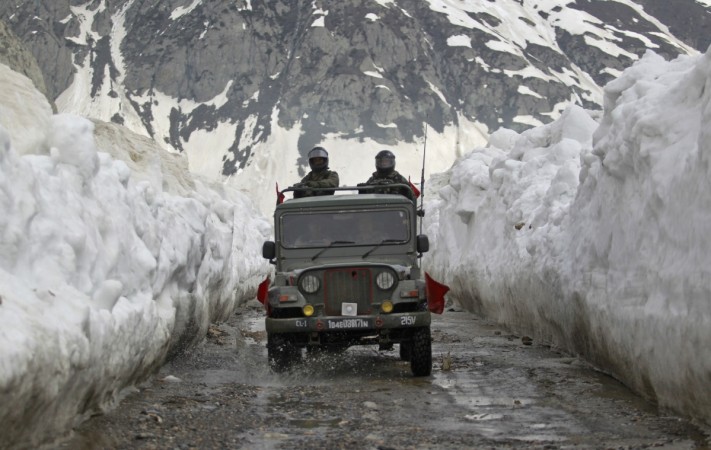 Indian army soldiers travel in a vehicle on a mountainous road covered by snow after the Srinagar-Leh highway was opened to traffic in Zojila. Zojila pass