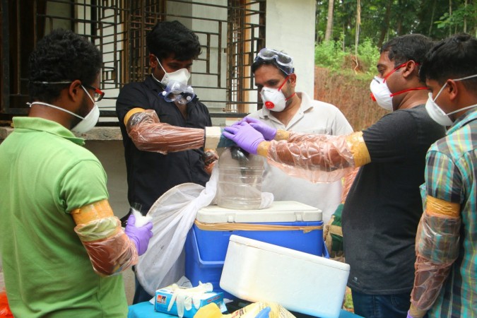 Animal Husbandry department and Forest officials deposit a bat into a container after catching it inside a well at Changaroth in Kozhikode in the Indian state of Kerala on May 21, 2018. Nipah virus outbreak in Kerala