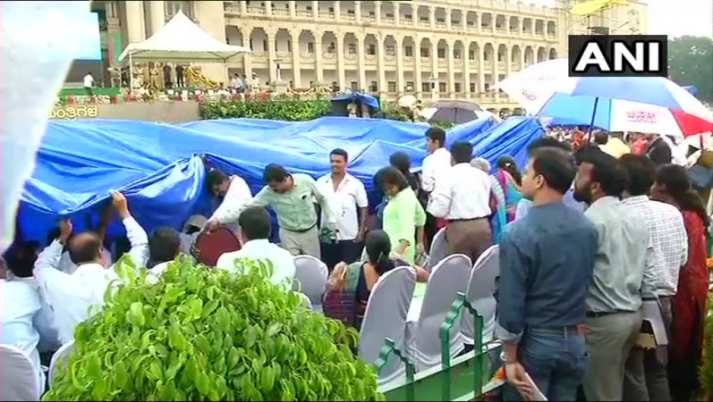Supporters take cover from rain under temporary shelter. Vidhana soudha