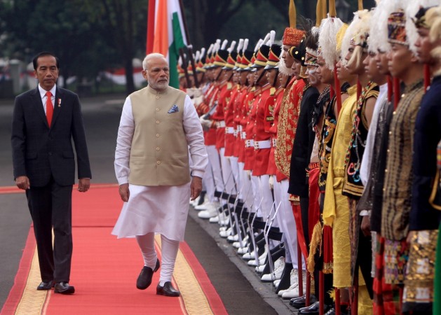 Indian Prime Minister Narendra Modi (R) accompanied by Indonesian President Joko Widodo (L) inspects an honour guard at the Presidential Palace in Jakarta Modi
