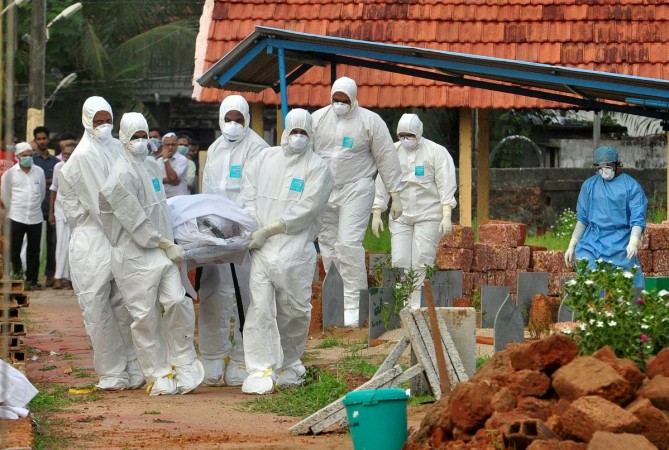 Doctors and relatives wearing protective gear carry the body of a victim, who lost his battle against the brain-damaging Nipah virus, during his funeral at a burial ground in Kozhikode, in the southern Indian state of Kerala, India, May 24, 2018. Nipah