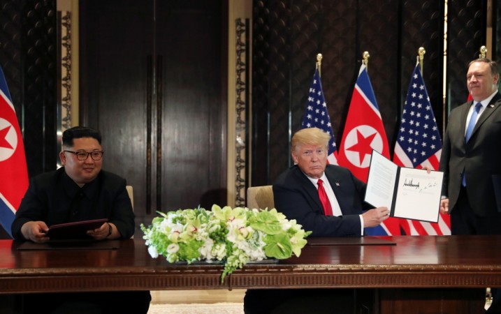 Donald Trump shows the document, that he and North Korea's leader Kim Jong Un signed acknowledging the progress of the talks and pledge to keep momentum going Donald Trump Kim Jong Un