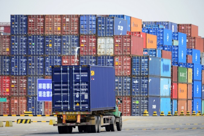 A truck transporting a shipping container is seen at a cargo terminal at a port in Qingdao, Shandong province, China April 6, 2018. Cargo