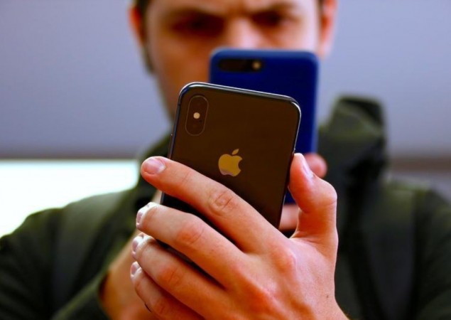 A customer uses his iPhone 7 to take a photograph of the iPhone X during the global launch of the new Apple product in central Sydney, Australia, November 3, 2017. Apple faces $9 million fine in Australia