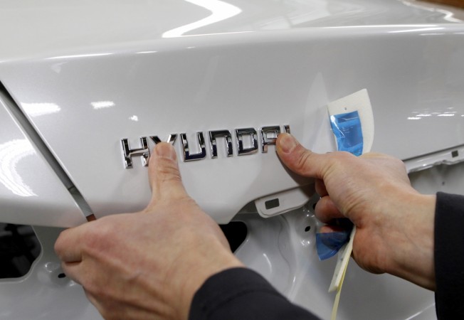 FILE PHOTO: A worker fixes the Hyundai logo on a vehicle at a plant of Hyundai Motor in Asan, south of Seoul Hyundai motors logo