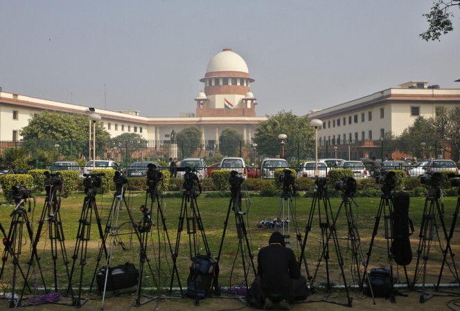 A television journalist sets his camera inside the premises of the Supreme Court in New Delhi February 18, 2014. Supreme Court of India