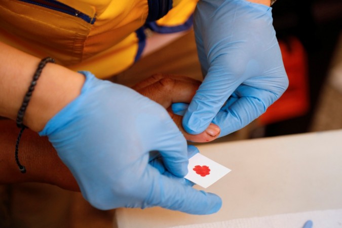 A paramedic takes a blood sample for DNA testing from a resident looking for a relative missing during the eruption of Fuego volcano at the morgue in Escuintla, Guatemala DNA test
