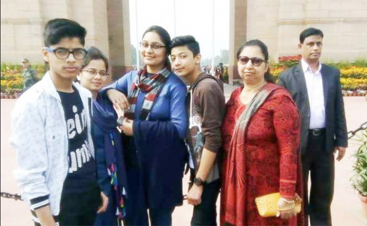 The family smiles at the camera in front of India Gate in Delhi. Burari family