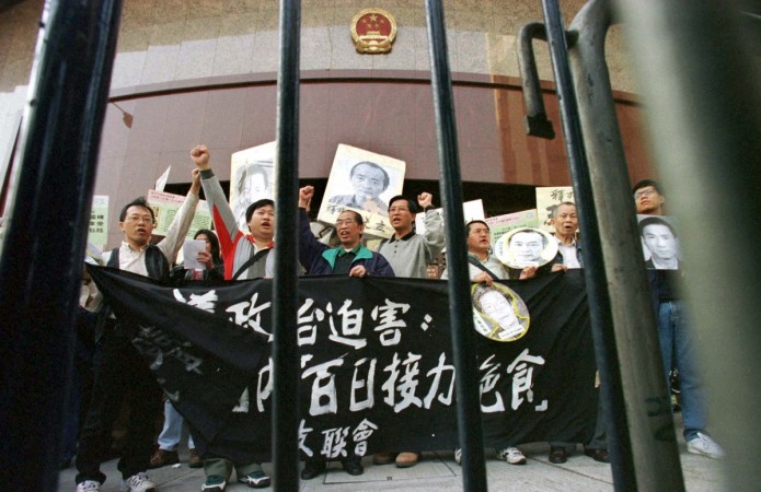 A group of pro-democracy activists, holding portraits Chinese dissidents, protest outside Xinhua News Agency in Hong Kong December 27. The group of about 30 Hong Kong marchers presented the news agency with a petition demanding the release of mainland dissidents - Wang Youcai, Qin Yongmin and Xu Wenli. pro-democracy protests in China