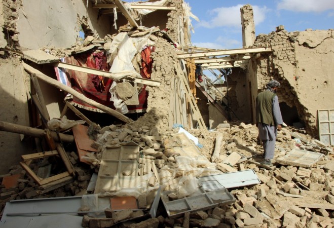 An Afghan man inspects a house destroyed during an air strike called in to protect Afghan and U.S. forces during a raid on suspected Taliban militants, in Kunduz house destroyed during an air strike