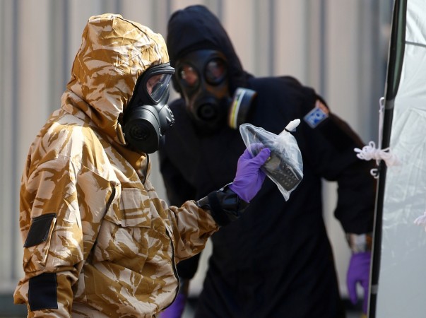 Forensic investigators, wearing protective suits, emerge from the rear of John Baker House, after it was confirmed that two people had been poisoned with the nerve-agent Novichok, in Amesbury, Britain, Forensic investigators