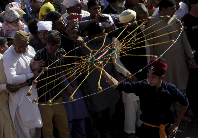 Sikh devotees watch a religious procession to mark the 546th birth anniversary of Guru Nanak Dev Ji, founder of Sikhism in Nankana Sahib outside Lahore, Pakistan, November 25, 2015. Sikh in Pakistan