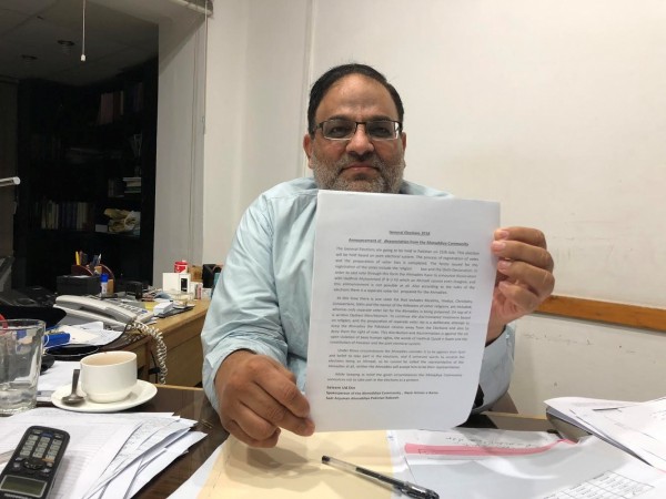 Salim Ud Din, a spokesman for the Ahmadi community, holds up an advertisement outlining during an interview with Reuters in the town of Rabwah, Pakistan Salim Ud Din
