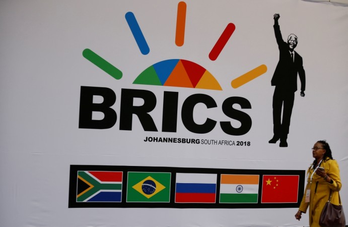 A delegate walks past a BRICS logo BRICS logo