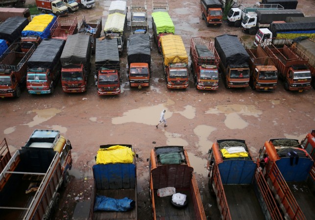 FILE PHOTO: A driver walks past parked trucks inside a depot during a nationwide strike in Ahmedabad, India, July 20, 2018. driver walks past parked trucks