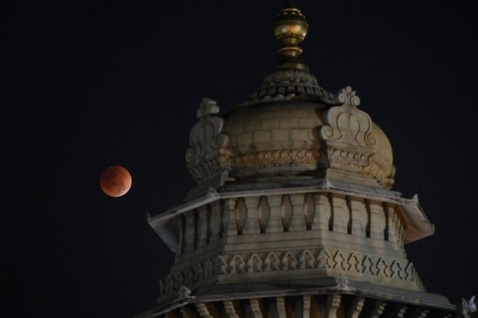 The moon is seen next to the dome of the Vidhana Soudha building during a lunar eclipse, referred to as the 'super blue blood moon', in Bangalore on January 31, 2018. blood moon