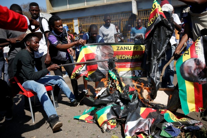 Supporters of the opposition Movement for Democratic Change party (MDC) of Nelson Chamisa burn an election banner with the face of Zimbabwe's President Emmerson Mnangagwa in Harare, Zimbabwe, August 1, 2018 Supporters of the opposition Movement for Democratic Change party (MDC) burn an election banner